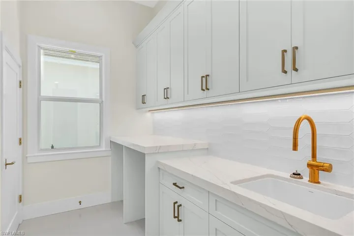 Laundry area featuring a sink, baseboards, and a wealth of natural light