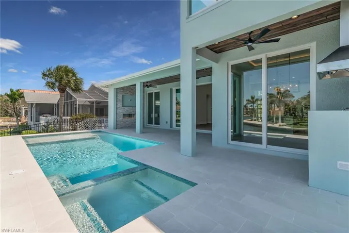 View of swimming pool with a patio, ceiling fan, a pool with connected hot tub, and fence