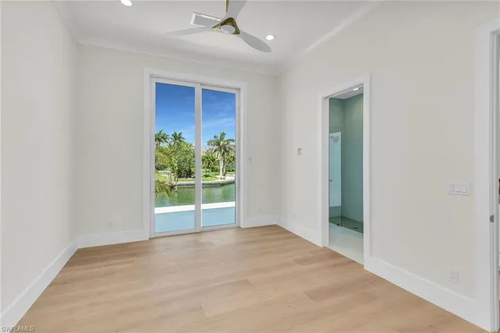 Empty room with ornamental molding, baseboards, and light wood-style floors
