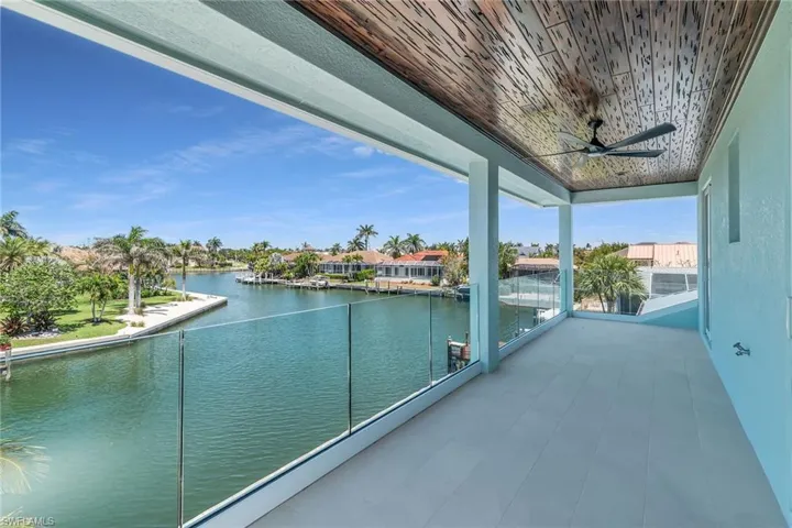 Balcony featuring a ceiling fan and a water view