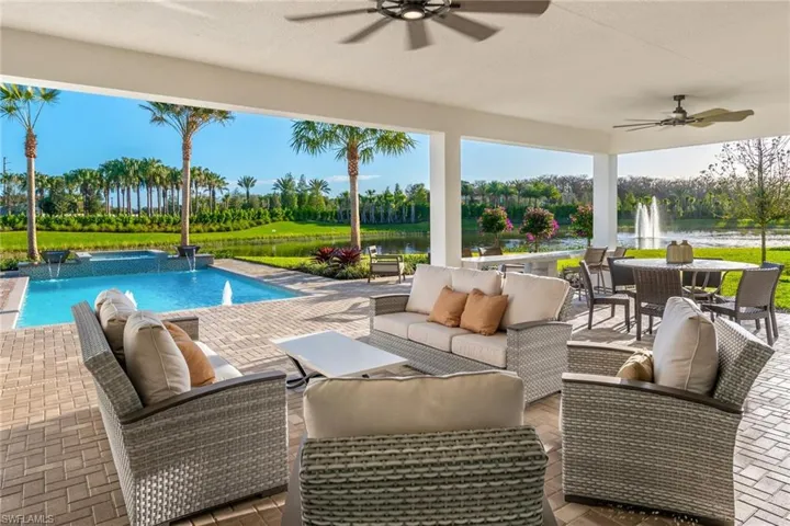 View of pool with a patio area, pool water feature, a water view, and an outdoor living space