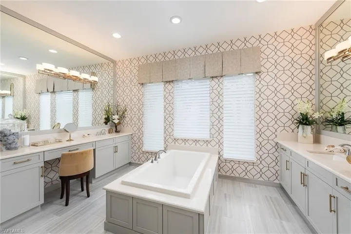 Bathroom featuring a washtub and vanity