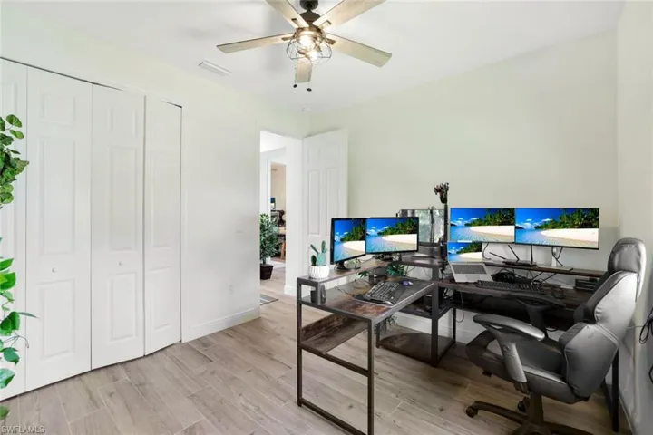 Office space with ceiling fan and light hardwood / wood-style flooring