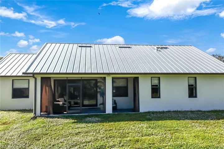 Rear view of property with a lawn
