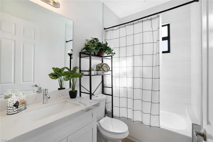 Full bathroom featuring shower / tub combo, vanity, and toilet