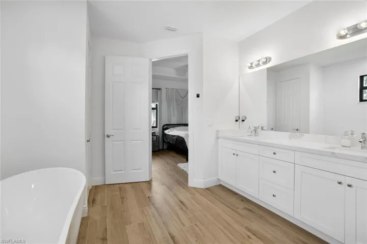 Bathroom featuring hardwood / wood-style flooring, a bathtub, and vanity