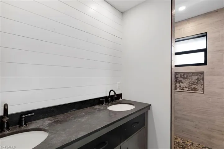 Bathroom featuring vanity and tiled shower