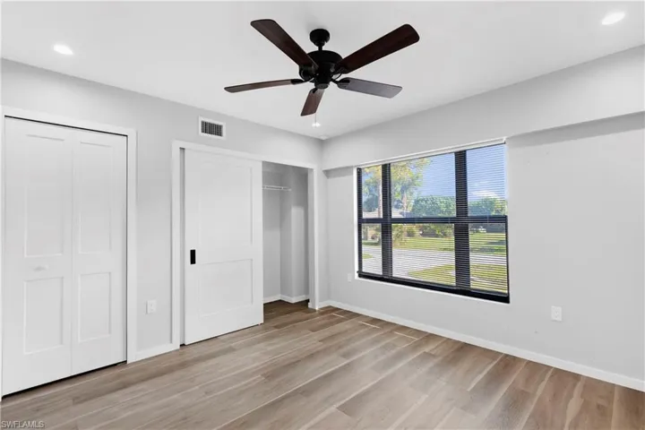 Unfurnished bedroom with ceiling fan and light wood-type flooring