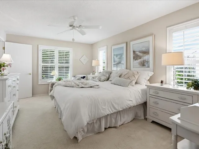 Primary bedroom with king sized bed and bahama shutters