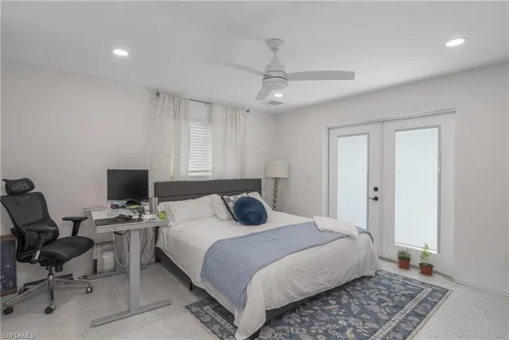 Bedroom featuring a ceiling fan, a desk, french doors, recessed lighting, and speckled floor