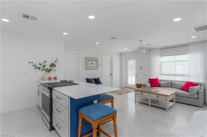 Kitchen with stainless steel range with electric stovetop, a peninsula, a breakfast bar, open floor plan, and recessed lighting
