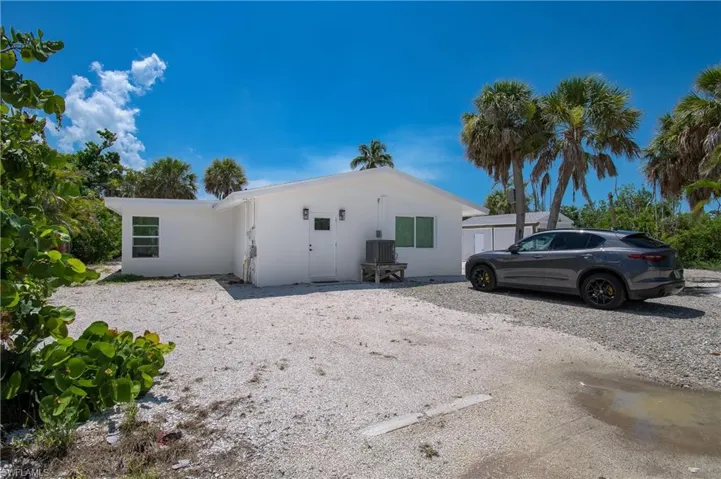 Road view of house featuring stucco siding