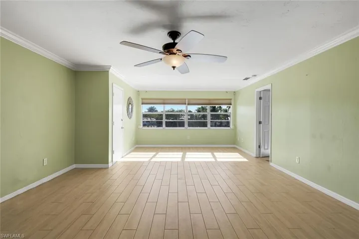 Spare room with wood tiled floors, ornamental molding, and ceiling fan