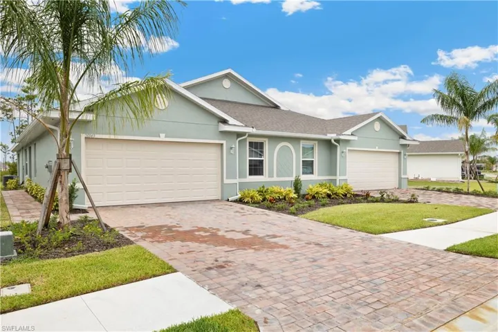 Ranch-style home featuring a garage and a front lawn