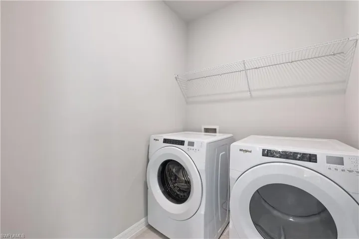 Laundry room with independent washer and dryer and tile patterned flooring