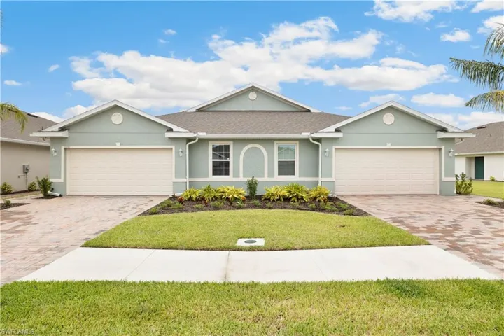 Ranch-style house featuring a garage and a front lawn