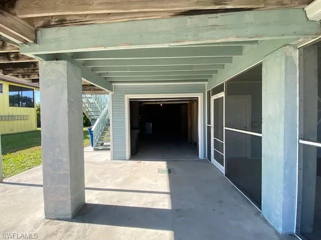 View of patio / terrace with a garage and stairs