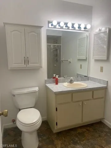Full bathroom featuring vanity, a shower stall, and stone finish flooring