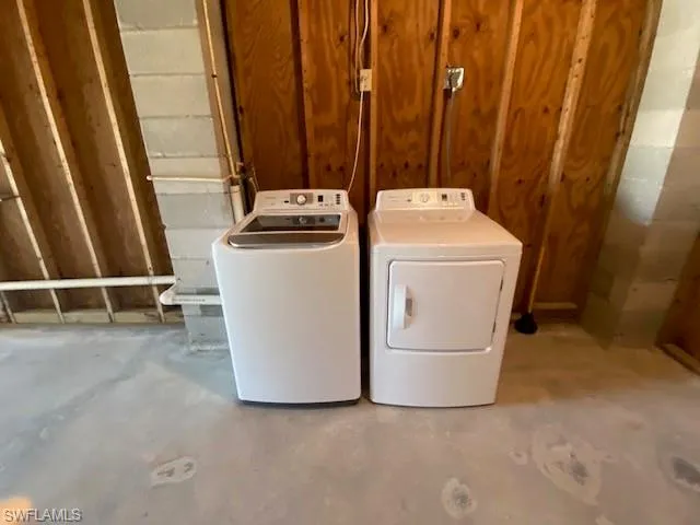 Laundry room with separate washer and dryer and concrete flooring
