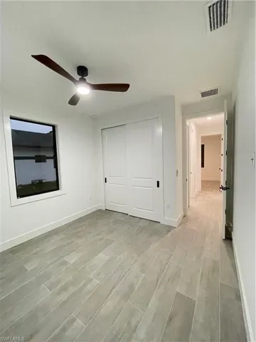 Unfurnished bedroom featuring ceiling fan, a closet, and light wood-type flooring