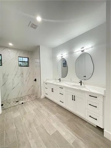 Bathroom featuring vanity and a tile shower