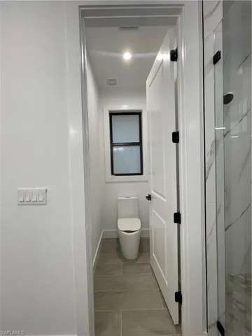 Bathroom featuring an enclosed shower and toilet