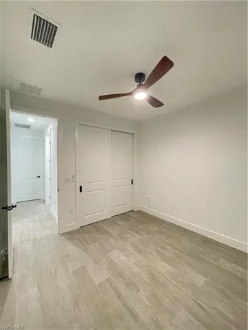 Unfurnished bedroom featuring light hardwood / wood-style flooring, a closet, and ceiling fan