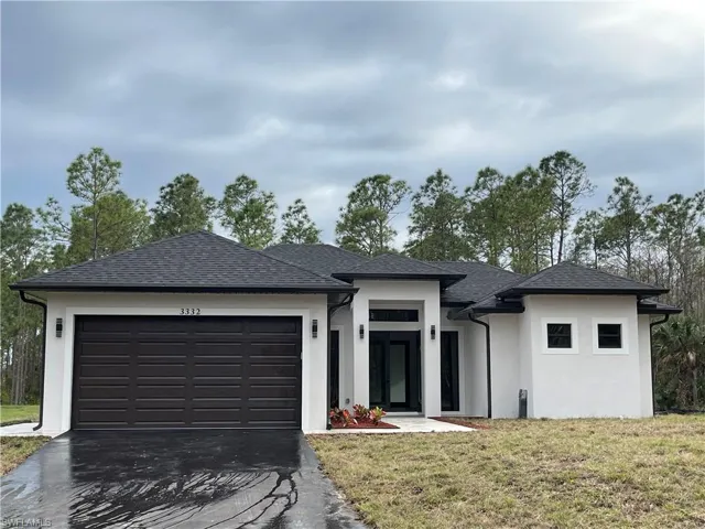 Prairie-style home featuring a garage and a front yard