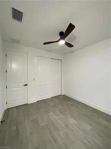 Unfurnished bedroom featuring hardwood / wood-style flooring, ceiling fan, and a closet