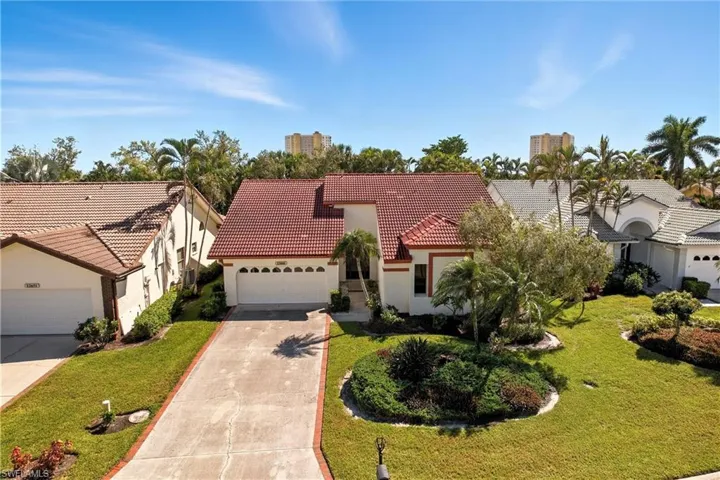 Mediterranean / spanish house featuring concrete driveway, a tile roof, stucco siding, a garage, and a front yard