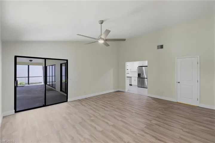 Unfurnished living room featuring light wood finished floors, high vaulted ceiling, and ceiling fan