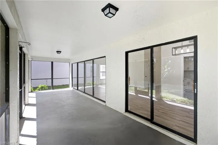 Unfurnished sunroom featuring a textured wall and concrete flooring