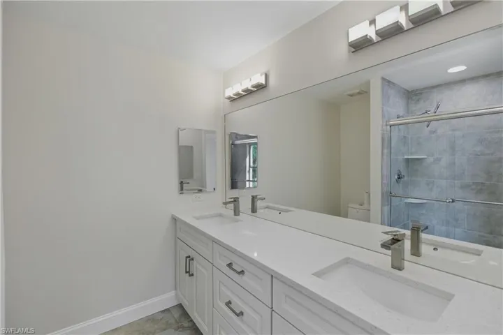 Bathroom with double vanity and a shower stall