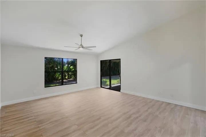 Spare room with light wood-style floors, vaulted ceiling, and ceiling fan