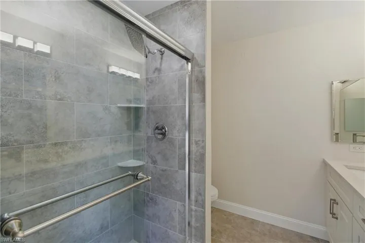 Bathroom with vanity, a shower stall, and light tile patterned floors