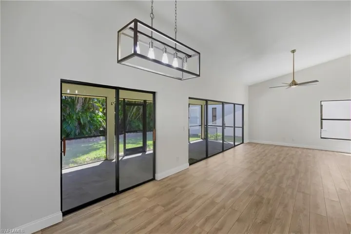 Unfurnished dining area featuring light wood-type flooring, high vaulted ceiling, and a ceiling fan