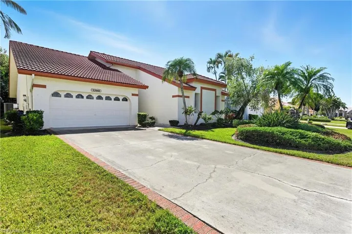 Mediterranean / spanish-style house featuring driveway, a garage, stucco siding, a front lawn, and a tiled roof