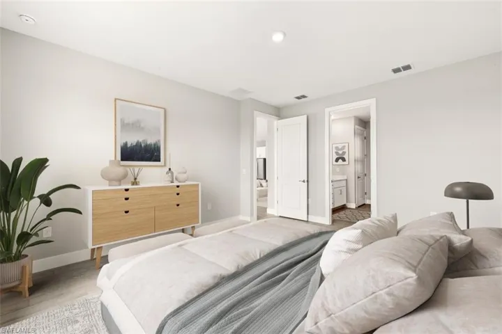 Recessed lighting, light wood-finish flooring, white walls, and a built-in wood-front dresser