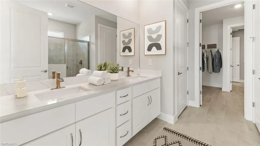 Dual white vanities with integrated sinks and bronze-finish fixtures