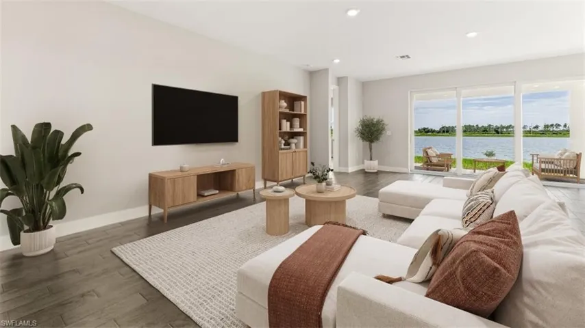 Recessed lighting, wood-finish flooring, and large sliding glass doors opening to a water feature