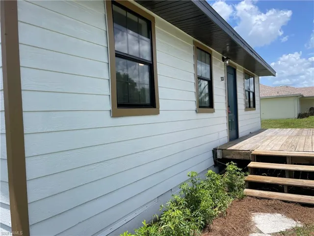 View of side of home with a wooden deck