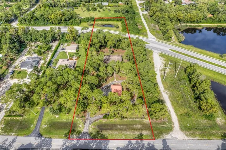 Birds eye view of property with a pond view