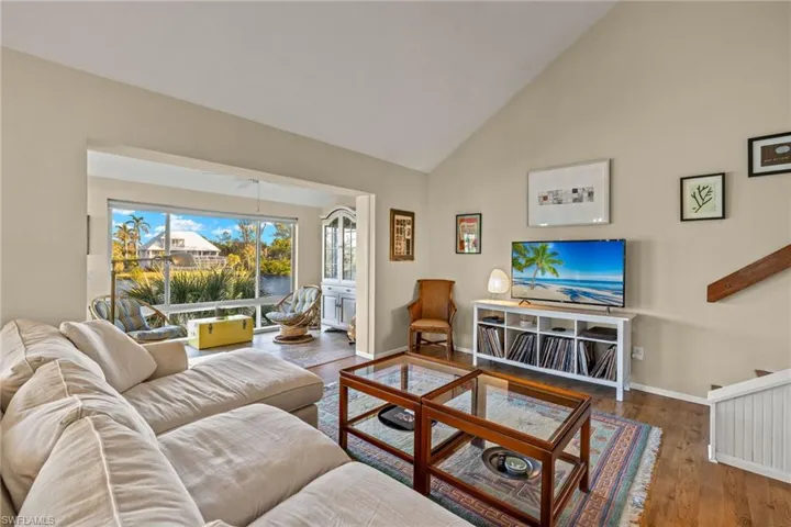 Living area with high vaulted ceiling and wood finished floors
