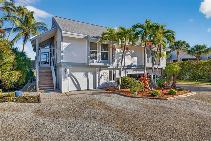 View of front of home featuring stairway, driveway, and a garage