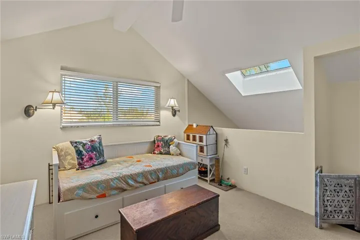Carpeted bedroom with a skylight and ceiling fan