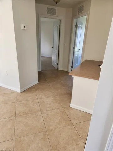 Hallway featuring baseboards and light tile patterned flooring