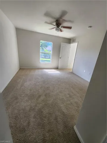 Empty room featuring carpet and ceiling fan