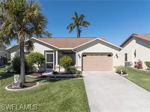 Ranch-style home with driveway, a front yard, and roof with shingles