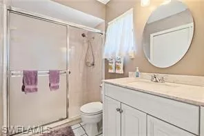 Bathroom with vanity, a stall shower, and light tile patterned flooring