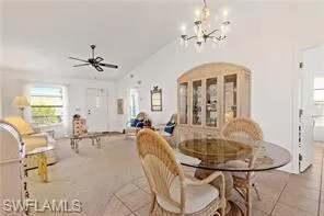 Living area with a chandelier, light wood finished floors, and a ceiling fan